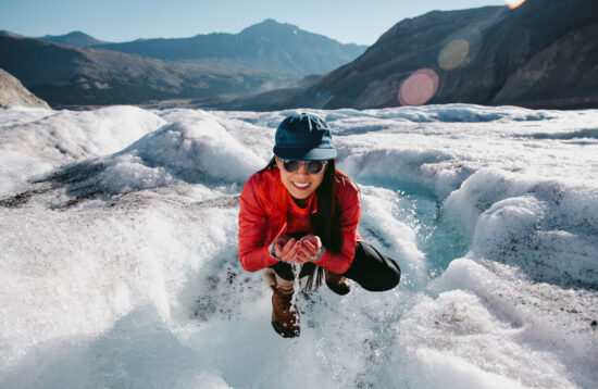 Woman-drinking-water-from-glacier