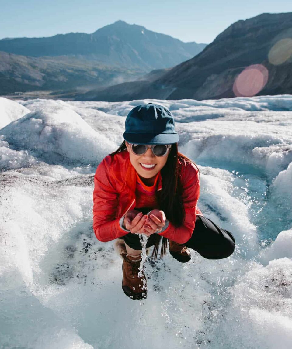 Woman drinking water from a glacier